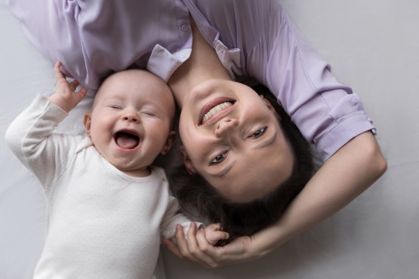 Mom and baby smiling on the floor 